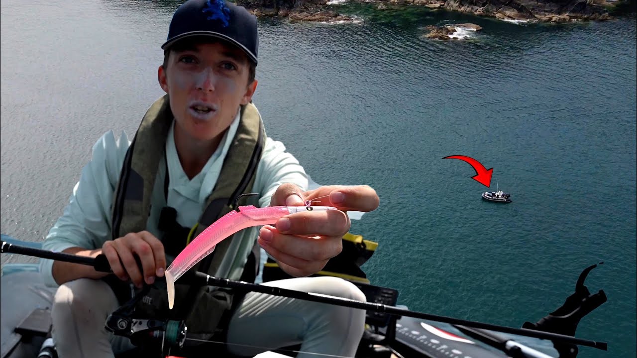 Angler holding the lure used to catch his biggest bass while inflatable boat fishing