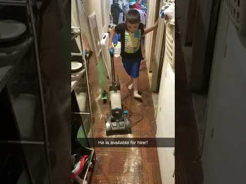 Dominic vacuuming the hallway