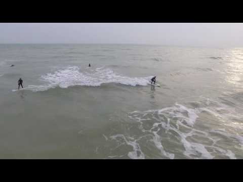 Aerial angle of surfers riding fun waves at Shoreham