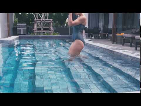 Girl in a swimsuit descends into the pool