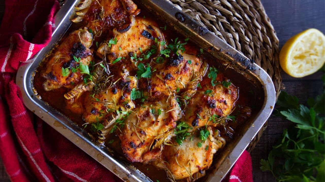 A large tray of baked mediterranean chicken thighs
