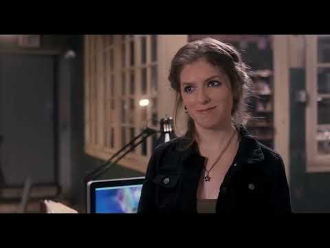 Pitch Perfect official trailer still: Beca holds a mic at the college a cappella finals as the crowd rises