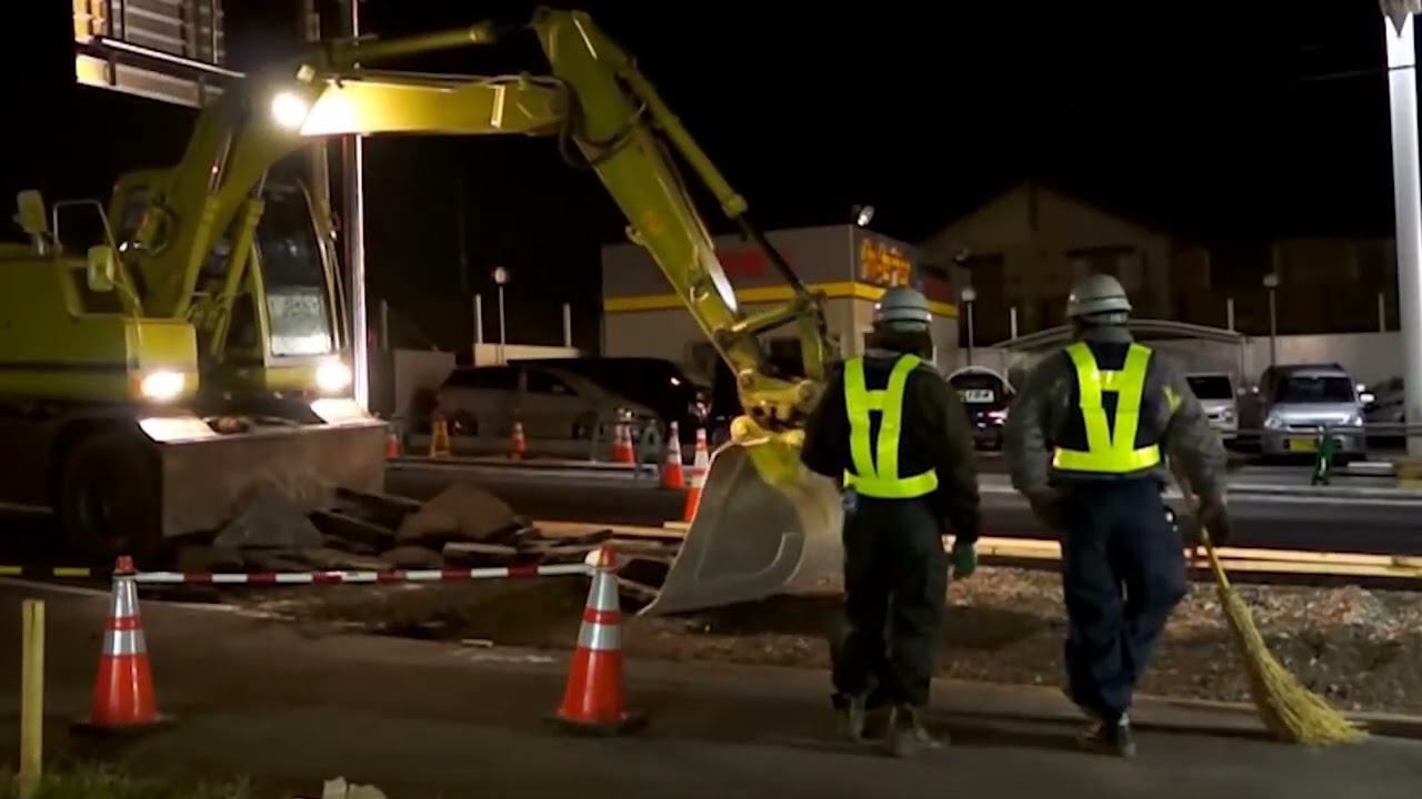 夜間の工事現場、ショベルカーで地面をガリガリ。