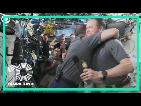 Russian cosmonaut, NASA astronaut hug during change of command ceremony on ISS
