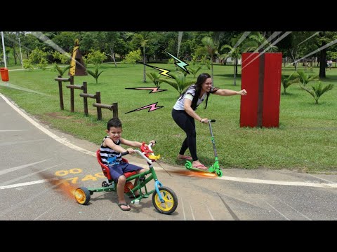 CRIANÇA BRINCANDO NO PARQUE COM PATINETE E TRICICLO