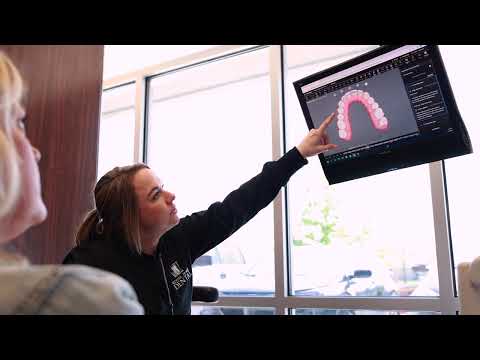 Dental team member pointing to digital dental impressions on computer screen