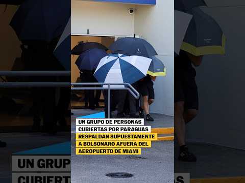 Un grupo de personas CUBIERTAS respaldan SUPUESTAMENTE a Bolsonaro afuera del aeropuerto de MIAMI