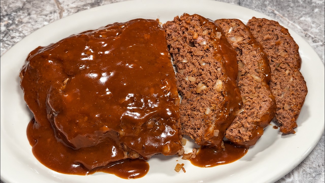 Homemade brown gravy meatloaf sliced and served with rich gravy