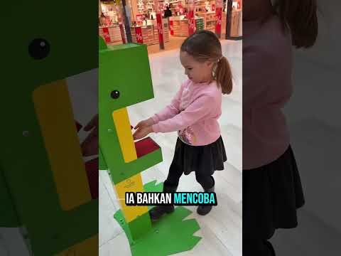 Naga hijau di mal ini memberikan permen kepada setiap anak.