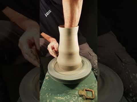 Wheel throwing a vase with a belly