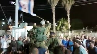 קבוצת נערים רוקדת עם חיילים ישראלים, בעוד ישראל מגנה על עצמה מפני טרור
