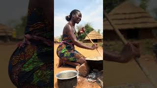 African village wife cooking for the husband