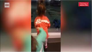 Two little girls have a dance off with airport employee
