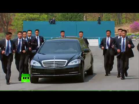 Men in Black: Kim's bodyguards run by his limo during summit