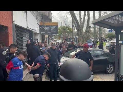 Football fans detained during violent clashes escorted out of a Buenos Aires police station | AFP