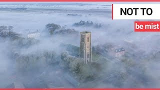 Stunning footage captures church spire piercing thick &#39;radiation fog&#39; covering village | SWNS TV