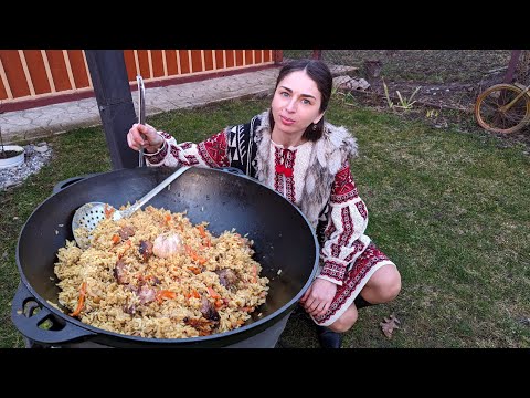 Woman is cooking TRADITIONAL Pilaf and chebureks in village. Crimean Tatar dishes with lamb
