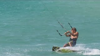 Kitesurfer does the dead man over rock wall at Currumbin, Gold Coast