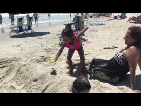 Binit under sand on beach
