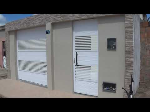 Fachada de muro externo, com portões para garagem e entrada social.