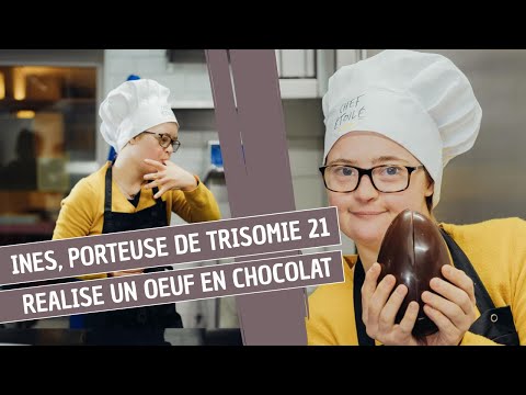 Inès, 23 ans porteuse de trisomie 21 et stagiaire dans une chocolaterie parisienne fabrique un oeuf.