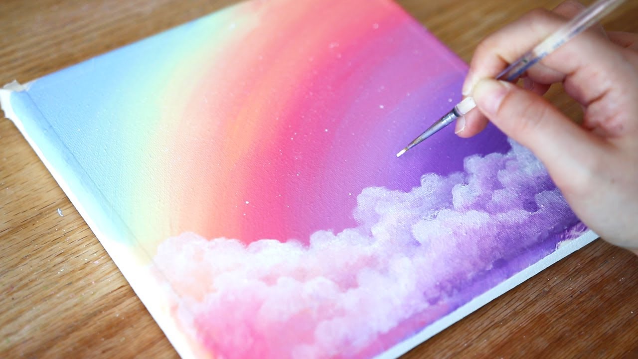 Acrylic painting of a dreamy sky with clouds and rainbow