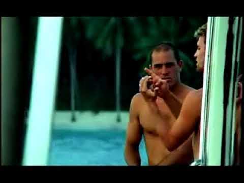 A Brokedown Melody official trailer still with surfers heading toward the lineup at dusk