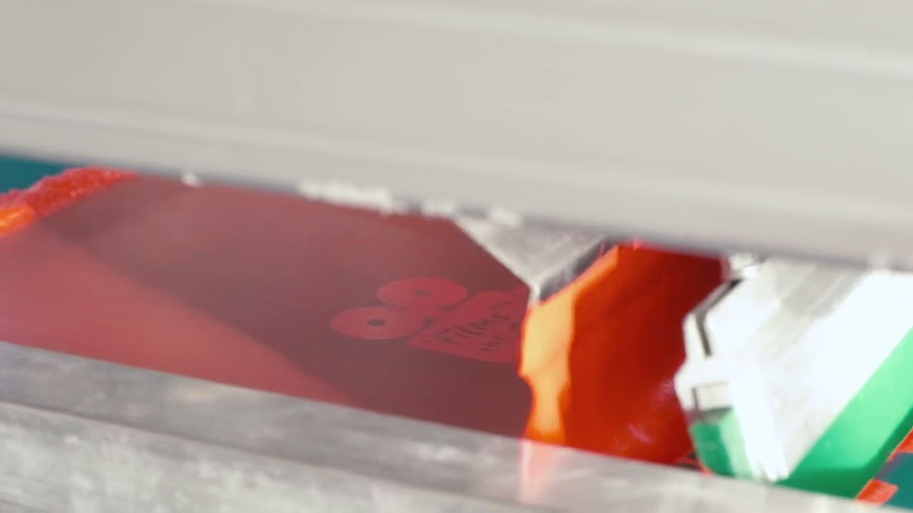 Screen printing on promotional merchandise — ink pushed through mesh stencil producing vivid opaque colours on fabric and flat surfaces