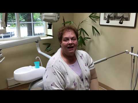 Woman in lavender blouse sitting in dental chair