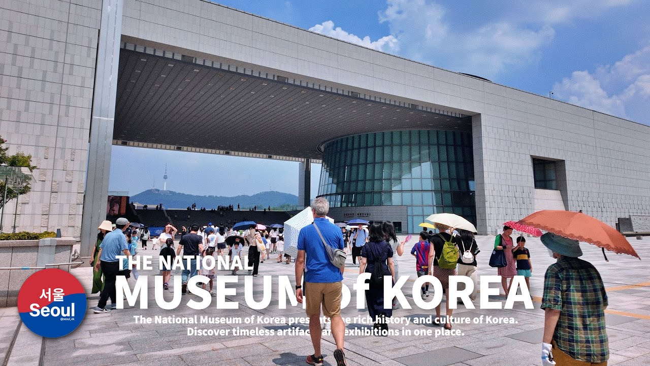 The main entrance hall of the National Museum of Korea in Seoul with high ceilings and visitors walking through the polished marble floors