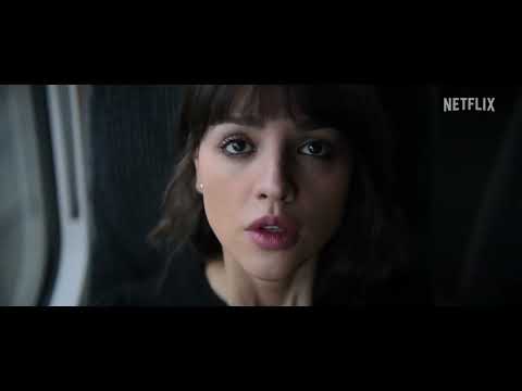 Trailer close-up: character framed by red laser lattice, danger implied