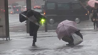 台風18号暴風雨に座り込む女性。Thewomanwhowasnotabletoenduretherainstormofthetyphoon.