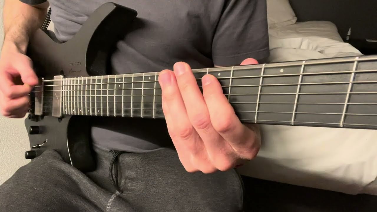 Roberto Barlocci playing a low, palm-muted Meshuggah-style djent riff on electric guitar