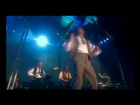 Trailer panel showing lasers, towering tripod prop, and chorus—visual shorthand for the album’s symphonic rock scale