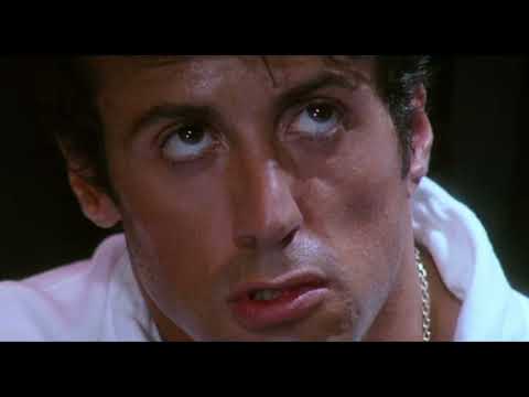 Rocky IV trailer still: Rocky and Drago face off under blinding arena lights as the crowd roars