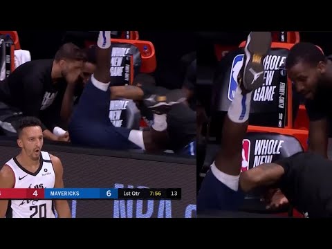Tim Hardaway Jr. falls over barrier near the bench after getting fouled