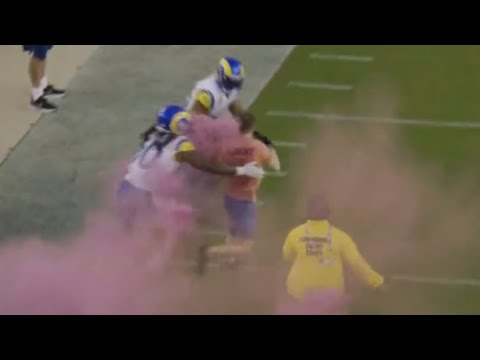 Bobby Wagner tackles a streaker on the field that's running with smoke bombs