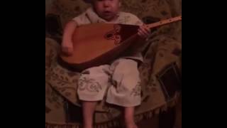 Маленький мальчик играет на домбре