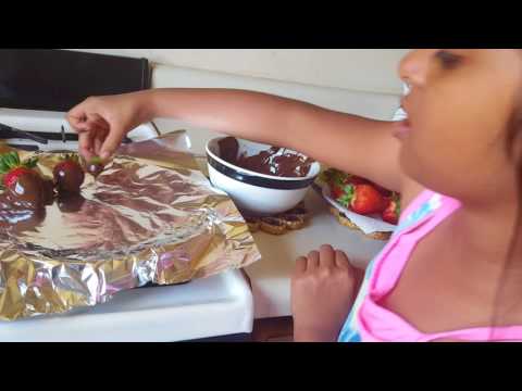 Jiya making chocolate coated strawberry.