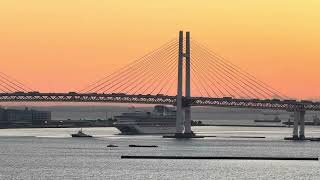 Watch as Diamond Princess Cruise Ship Narrowly Passes Under Yokohama Bay Bridge with Sunrise lit Sky