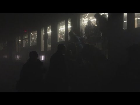 Commuters climb out of Brussels Metro train after explosion