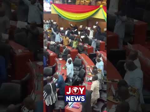 Minority MPs hold placards to express their disapproval after the Speaker dismissed their motion.