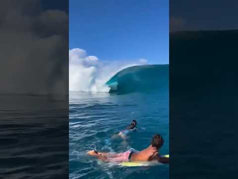 Onda gigante pegando surfista.