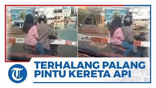 Viral Video Momen Sejoli yang Berboncengan Naik Sepeda Motor Terhalang Palang Pintu Kereta Api