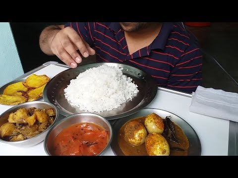 eating show rice with egg curry potato dum fried potato and tomato chatni