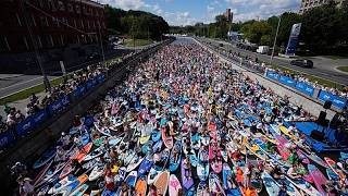 Kostümierte Stand-up-Paddler gleiten beim Karneval über Fluss in Moskau