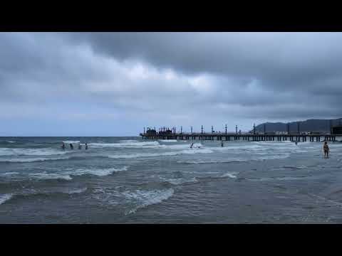 Beach in Alassio next to Molo di Alassio on a cloudy day.