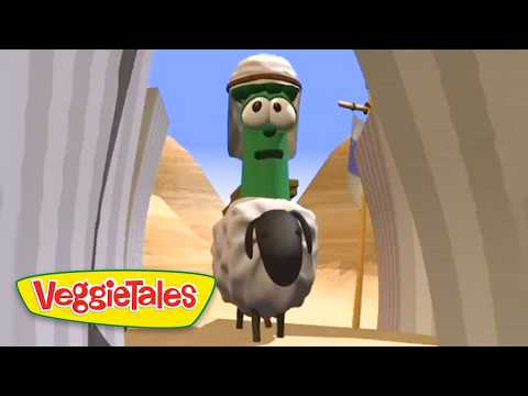 Green VeggieTales character wearing a head covering rides a fluffy gray sheep toward the camera in a desert canyon, VeggieTales logo in corner.