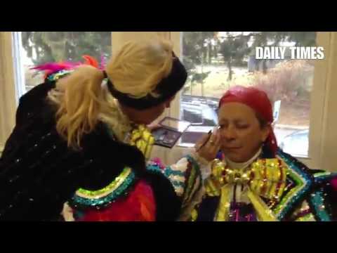 Greater Overbrook String Band banjo/bass player Tracey Black applies makeup to fellow Mummer Tom Coo