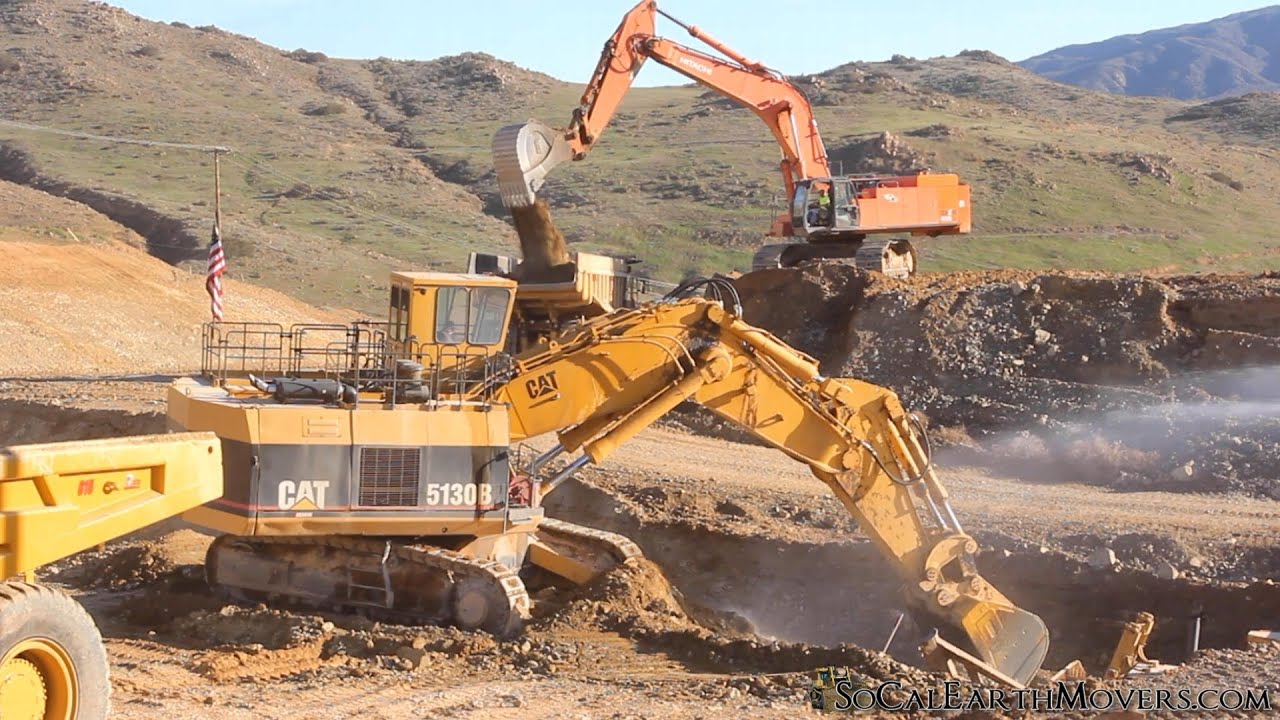 CAT 5130B excavating virgin rock for new roadway slot